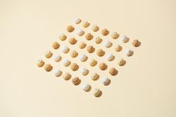 Speckled eggs  in rows on pastel yellow background