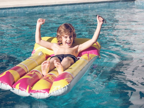 Cheerful boy relaxing on inflatable float