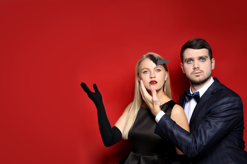 Concept of Halloween, young man and woman on red background