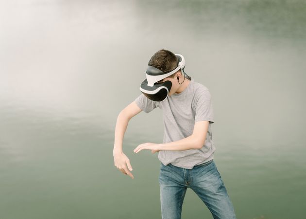 Young teenager with virtual reality glasses outdoors