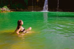 Anonymous woman looking at waterfall
