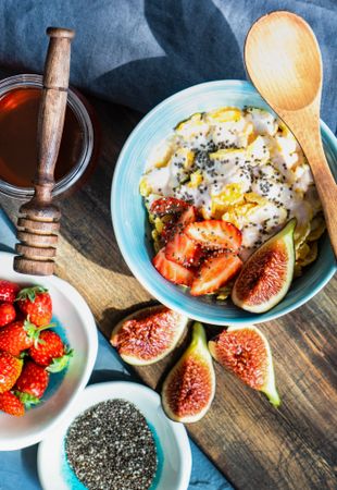 Traditionally healthy breakfast with chia, honey, figs and strawberry on board