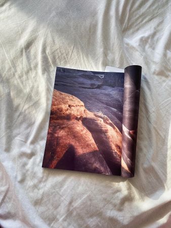 Open magazine on bed sheets