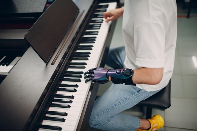 Young man with prosthetic hand playing the piano