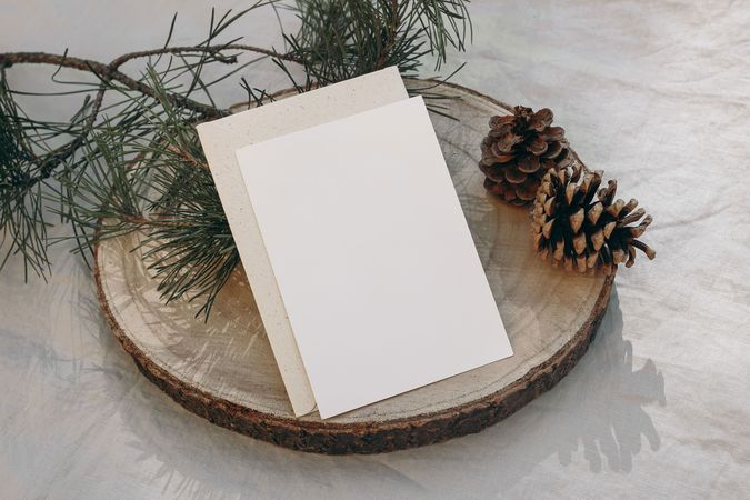 Blank greeting card, invitation mockup on wintry cut wooden round board