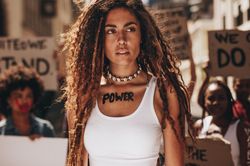Woman with word power written on her chest and looking away