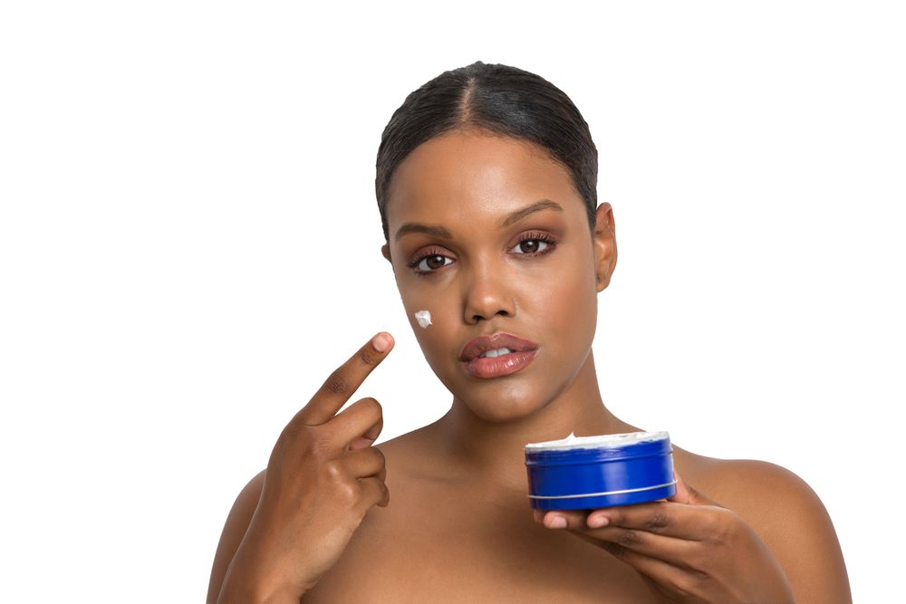 Woman applying cream on her face