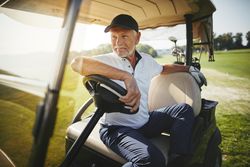 Man sitting in golf cart on court