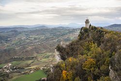 Stone peak with castle overgrown with trees and bushes rush into sky