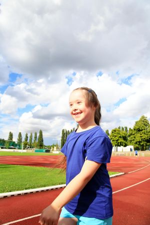 Happy child walking along running track