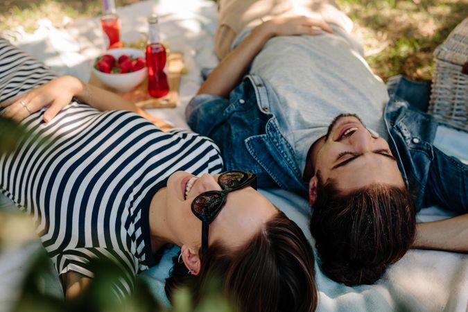 Cheerful couple on picnic relaxing at a park