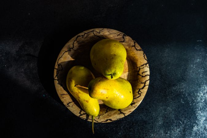 Top view of pears on wooden plate