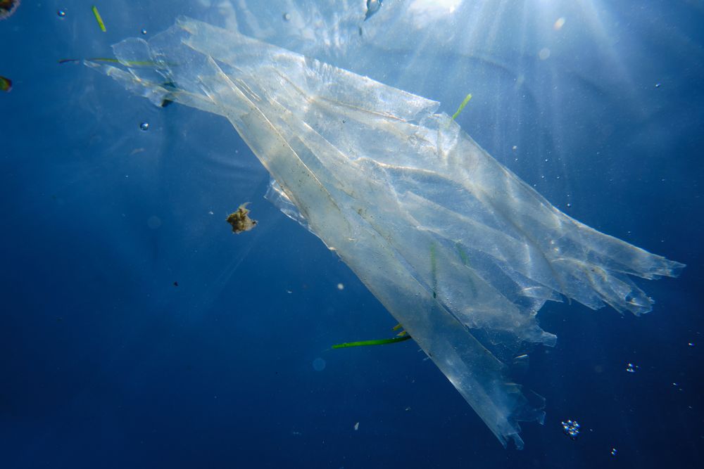 Polluted ocean and plastic bag floating in it