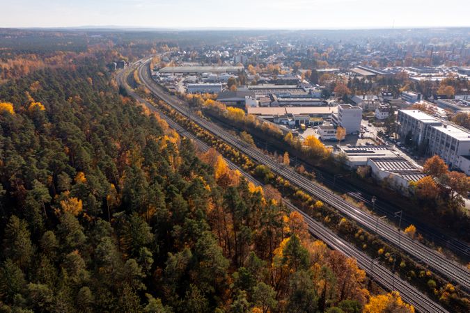 Railways through autumn forest near Nuremberg city, drone aerial view