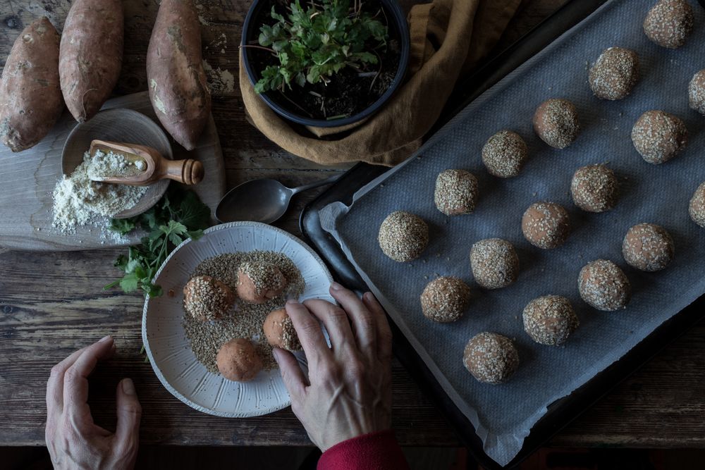Person rolling in breadcrumbs sweet potatoes