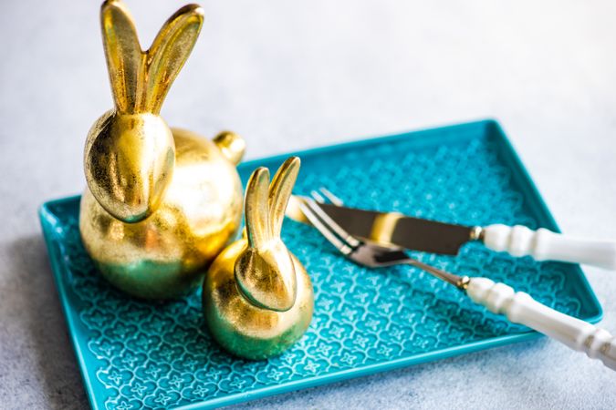 Place setting for festive Easter dinner with golden rabbit figurines