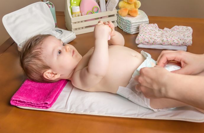 Parent changing diaper of baby