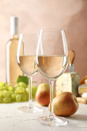 Grape, cheese, pears, glasses and bottle with wine, on blank background, copy space