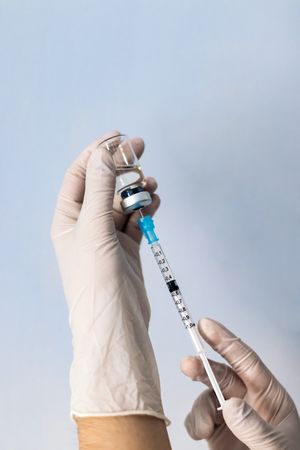 Hand holding syringe with vaccine. Vaccination concept. Covid-19