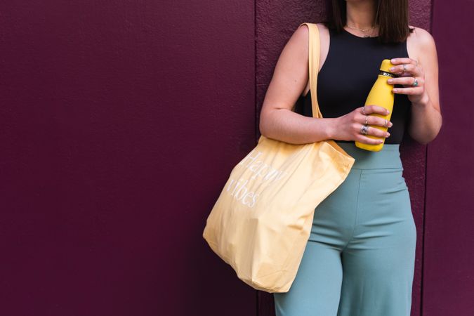 Crop woman with eco friendly bag in city