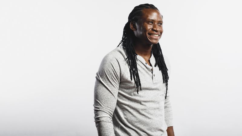Muscular man with dreadlocks isolated on neutral background