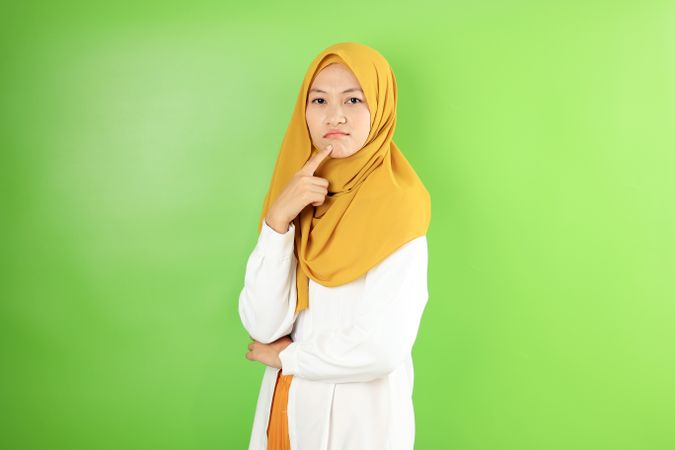 Asian Young Hijab Woman Pouting and Thinking Looking at Camera