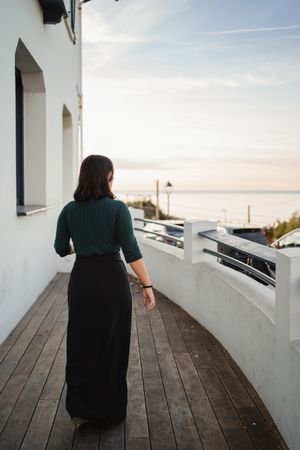 Pensive woman walking on balcony