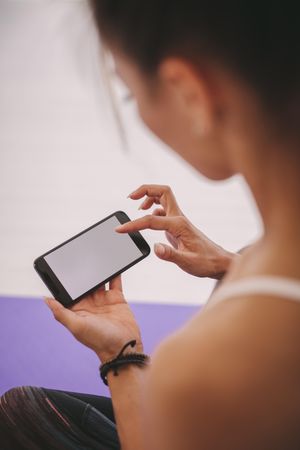 Closeup shot of woman using mobile phone at fitness studio