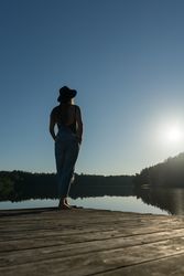 Young female standing on pier on nature