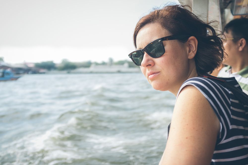 Woman looking at waving sea from ship