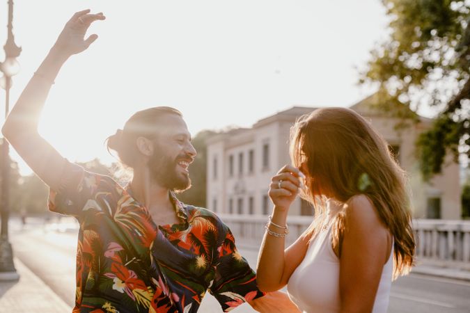Happy playful couple on street in sunset