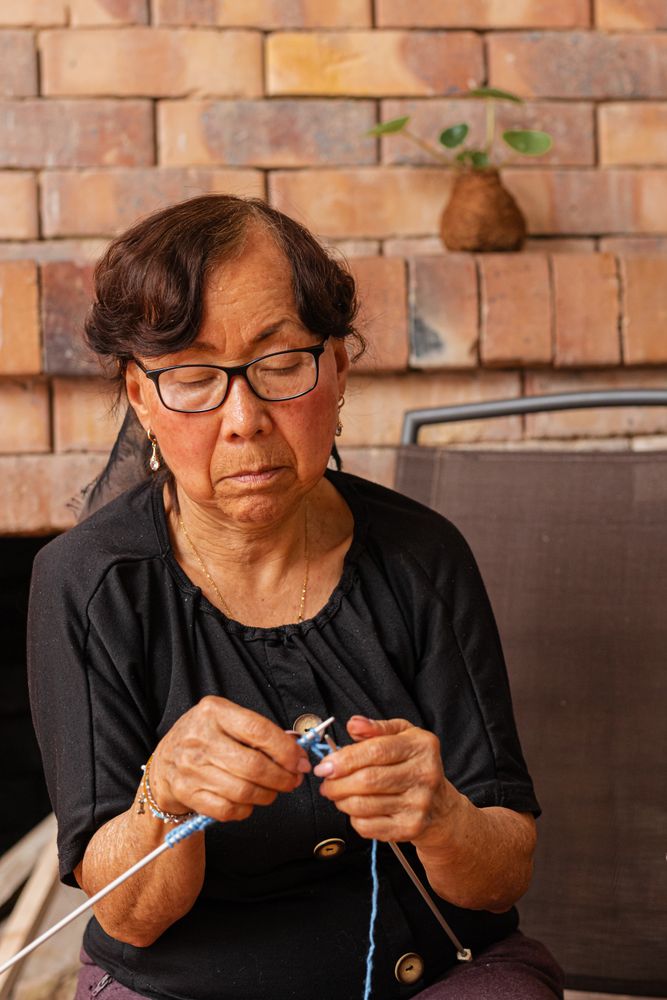 Tranquil threads. Mature Latina woman's knitting retreat.