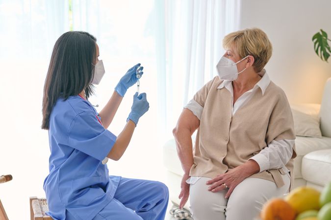 Unrecognizable physician filling syringe with vaccine against pa
