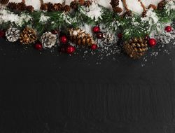 Christmas holiday top border decor on dark stone with snow