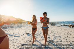 Female friends enjoying summer vacation with toy water guns 4Nqng5