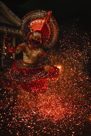 Man performing Theyyam ritual form of dance worship outdoor