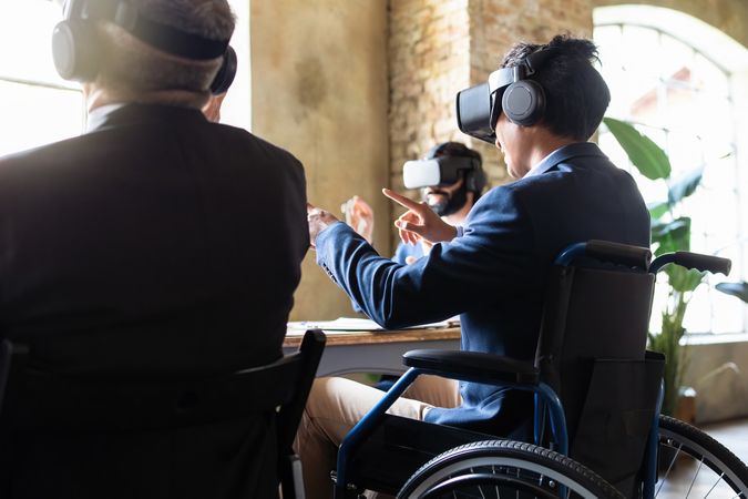VR experience around meeting table with man in wheelchair