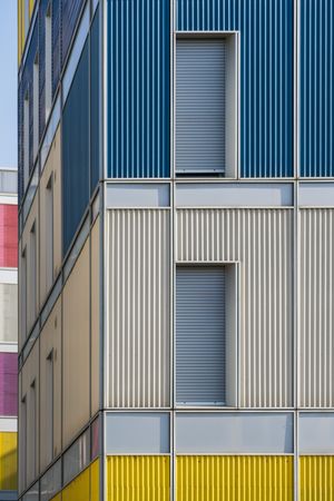Facade of modern multicolored building with narrow windows