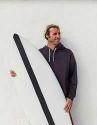 Smiling man standing with surf board