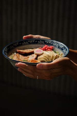 Crop female with portion of ramen under sunlight