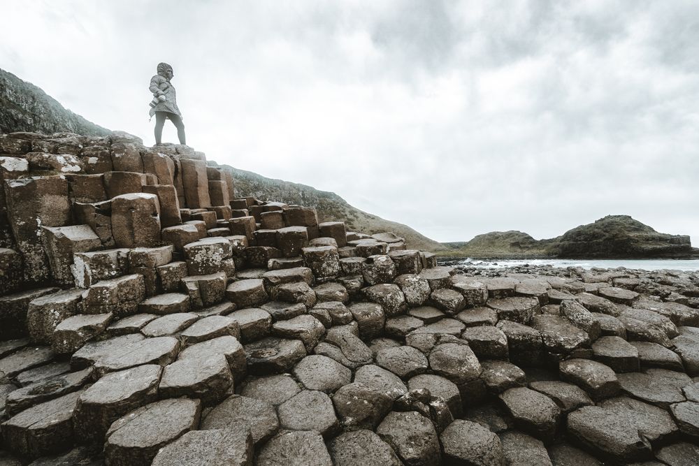 Female standing on cliff and contemplating