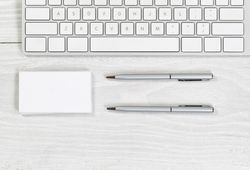 Blank business cards and pens on plain desktop