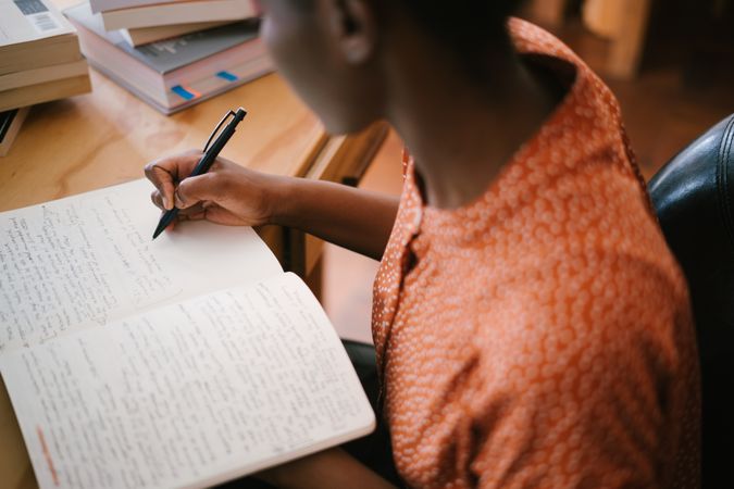 Teenage girl writing on a notebook