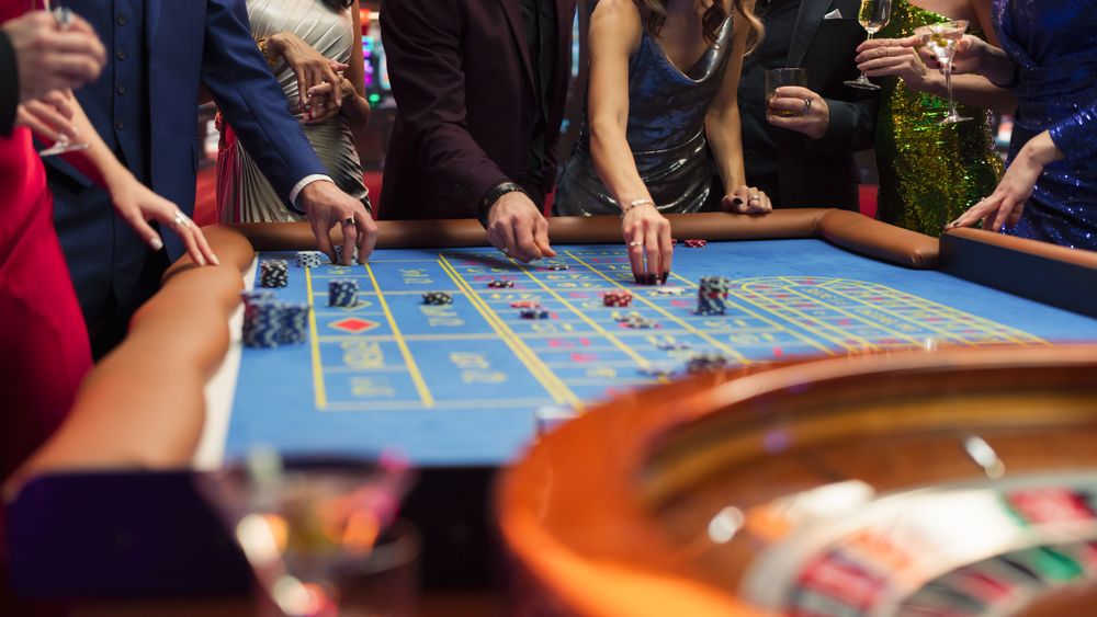 Anonymous Group of Elegant Casino Guests Placing Bets on a Table.