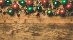 Tree ornaments on wooden background, large and small red, green and gold baubles, copy space