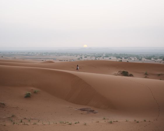 Woman in summer dress walking in desert