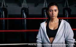 Portrait of female boxer standing in the ring in hoodie 5qkVLa