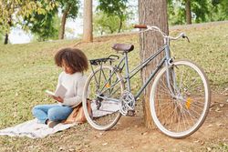 Black female reading book in nature