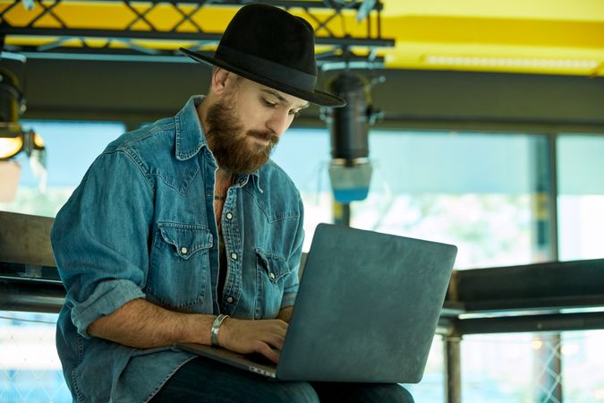 man seriously typing on laptop