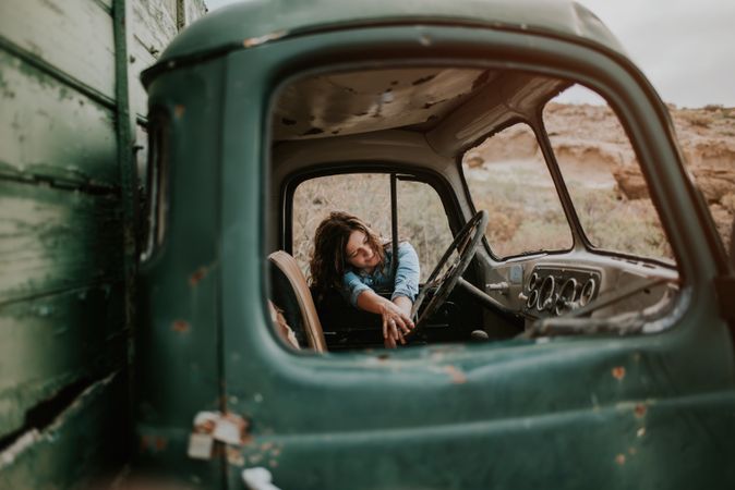 Relaxed female leaning on old truck